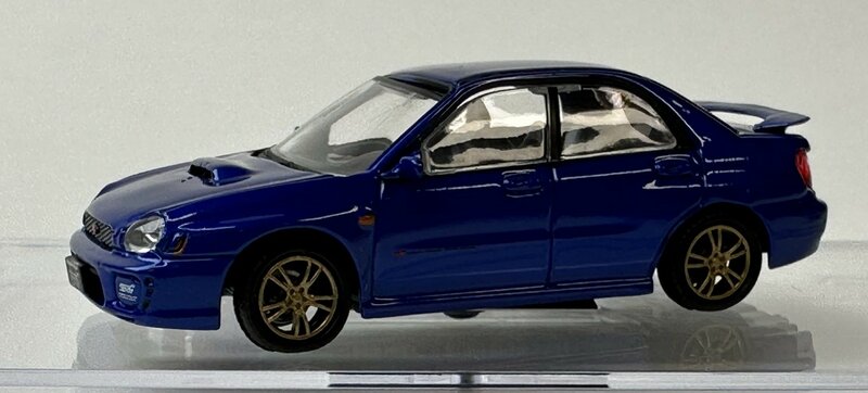 BM Creations 1:64 Subaru Impreza WRX LHD 2001 met extra wielen blauw, in vitrine