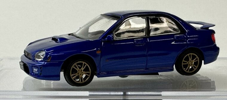 BM Creations 1:64 Subaru Impreza WRX LHD 2001 met extra wielen blauw, in vitrine